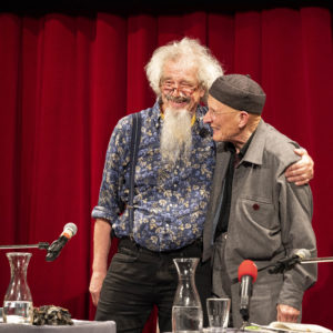 Peter Angerer, Bodo Hell Arm in Arm auf der Bühne bei der Eröffnung des 15. Literaturfest