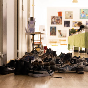 Ausgezogene Schuhe vor dem Saal des Toihaus Theater