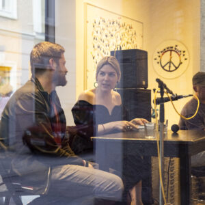 Autor:innen Alexandru Bulucz und Frieda Paris im Fenster der Galerie Ferner bei den Galeriedialogen