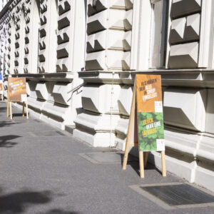 Literaturfest-Plakate "Als wären wir alle in Sirup eingelegt" und "Glück war eine Tätigkeit" auf Plakatständer vor dem Toihaus Theater