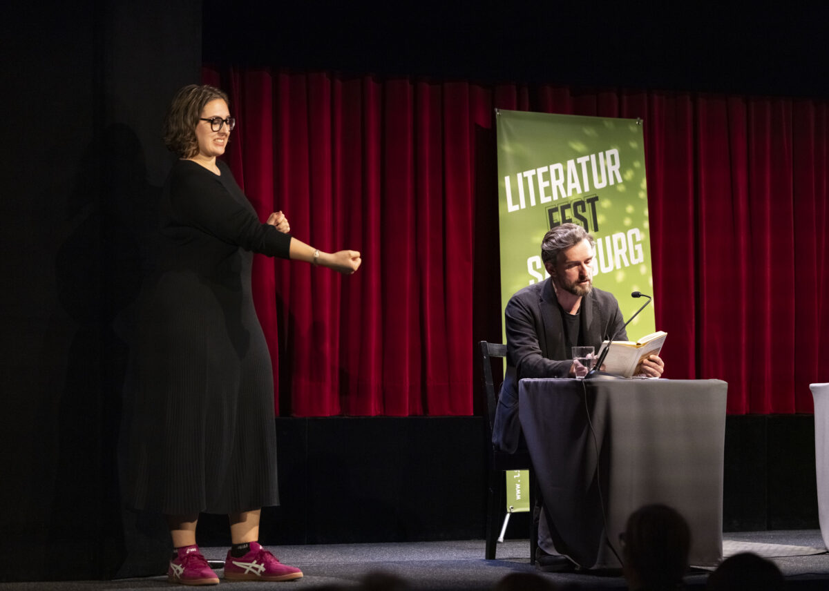 Autor Reinhard Kaiser-Mühlecker und eine ÖGS-Dolmetscherin auf der Bühne bei der Eröffnung des 17. Literaturfest