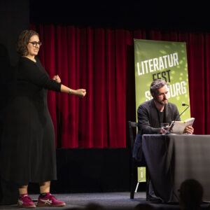 Autor Reinhard Kaiser-Mühlecker und eine ÖGS-Dolmetscherin auf der Bühne bei der Eröffnung des 17. Literaturfest